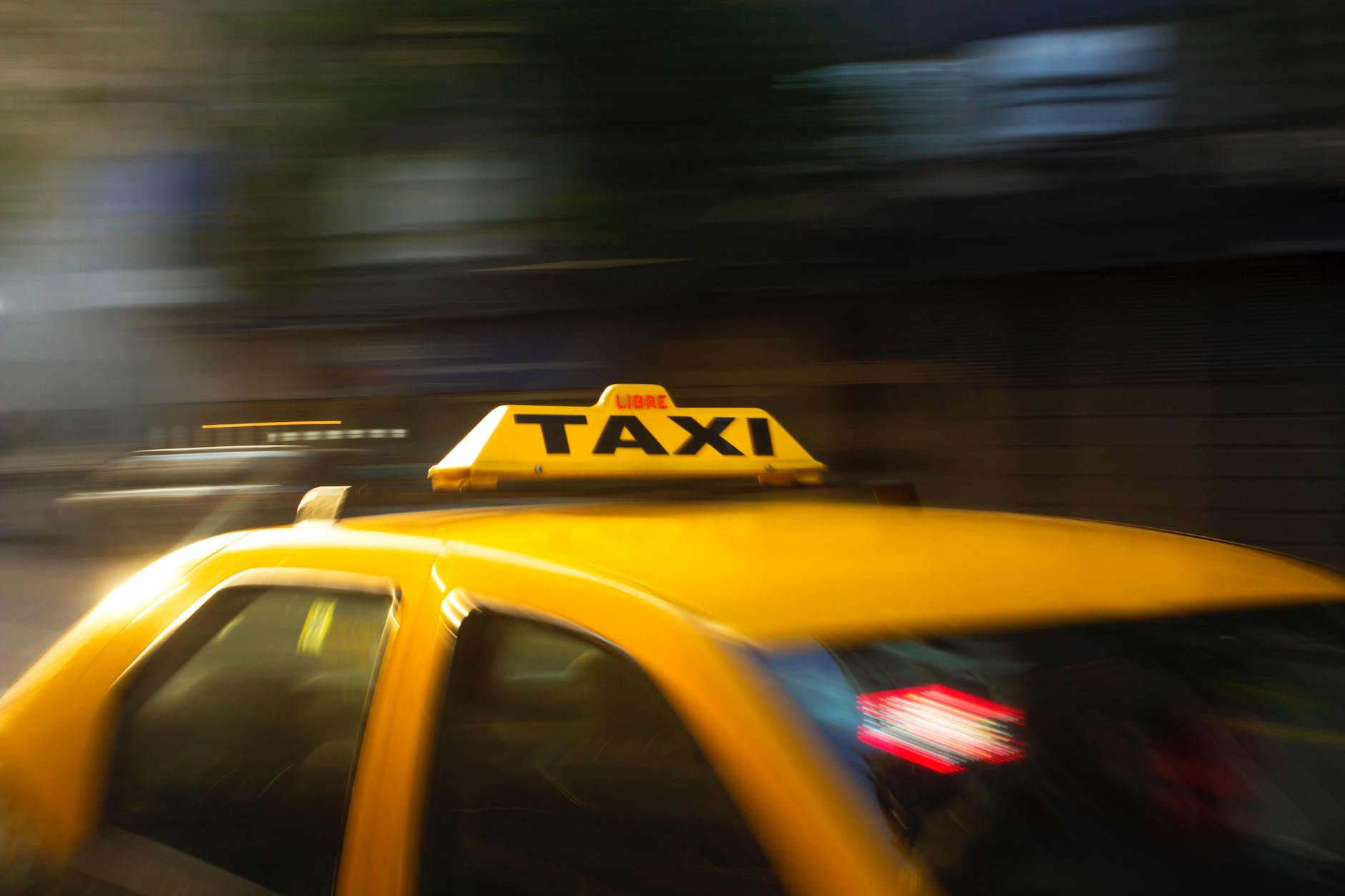 panning photography of yellow taxi
